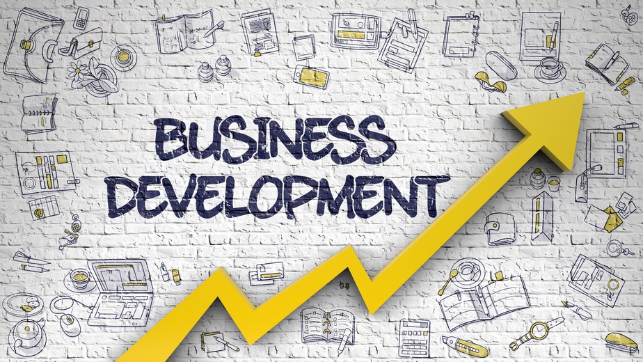 Business Development graphic with brick wall and yellow arrow